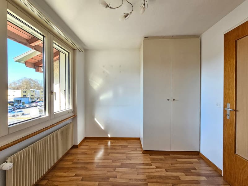 empty room, wooden floor, white walls, large window, white wardrobe, radiator