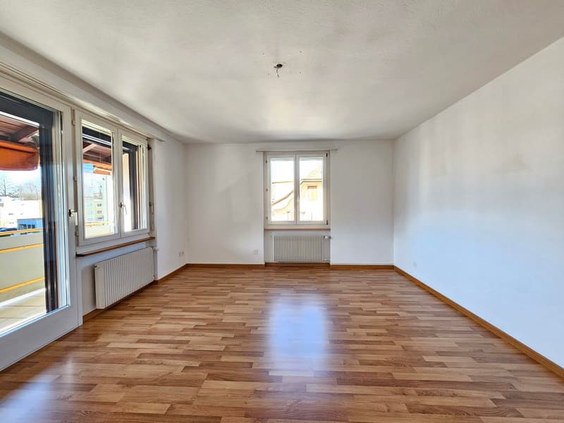 empty room, wooden floor, white walls, two windows, two radiators, balcony