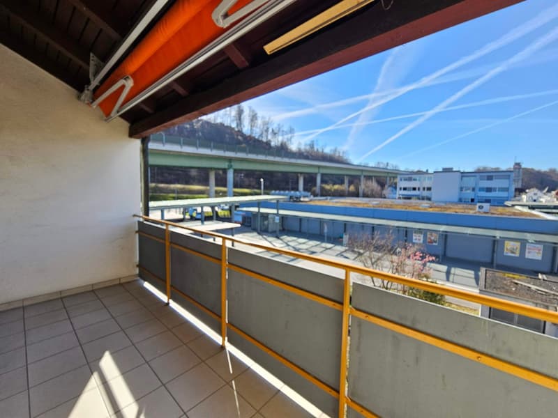 tiled floor, yellow railing, view of a bridge and buildings