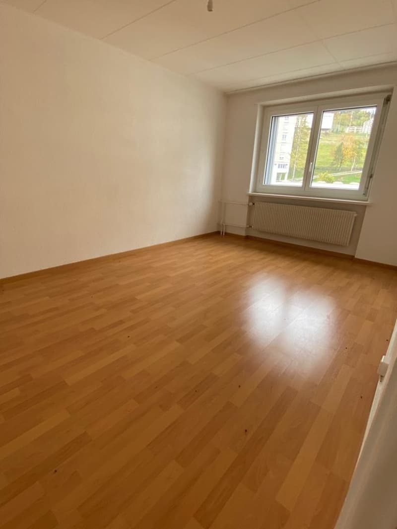 empty room, wooden floor, white walls, large window, radiators
