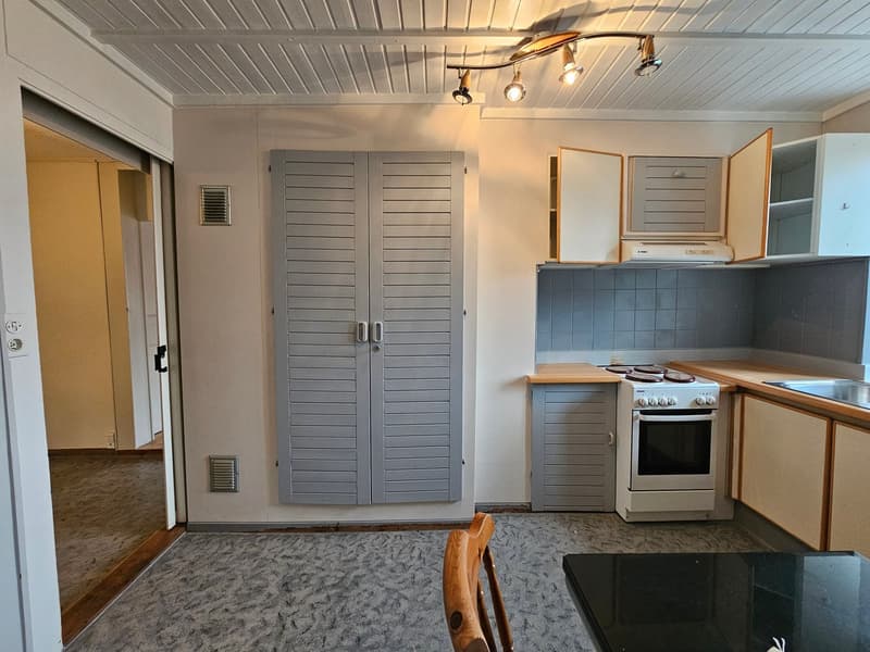 kitchen, wooden chair, white cabinets, tiled floor, stove and oven, sink, track lighting, double doors