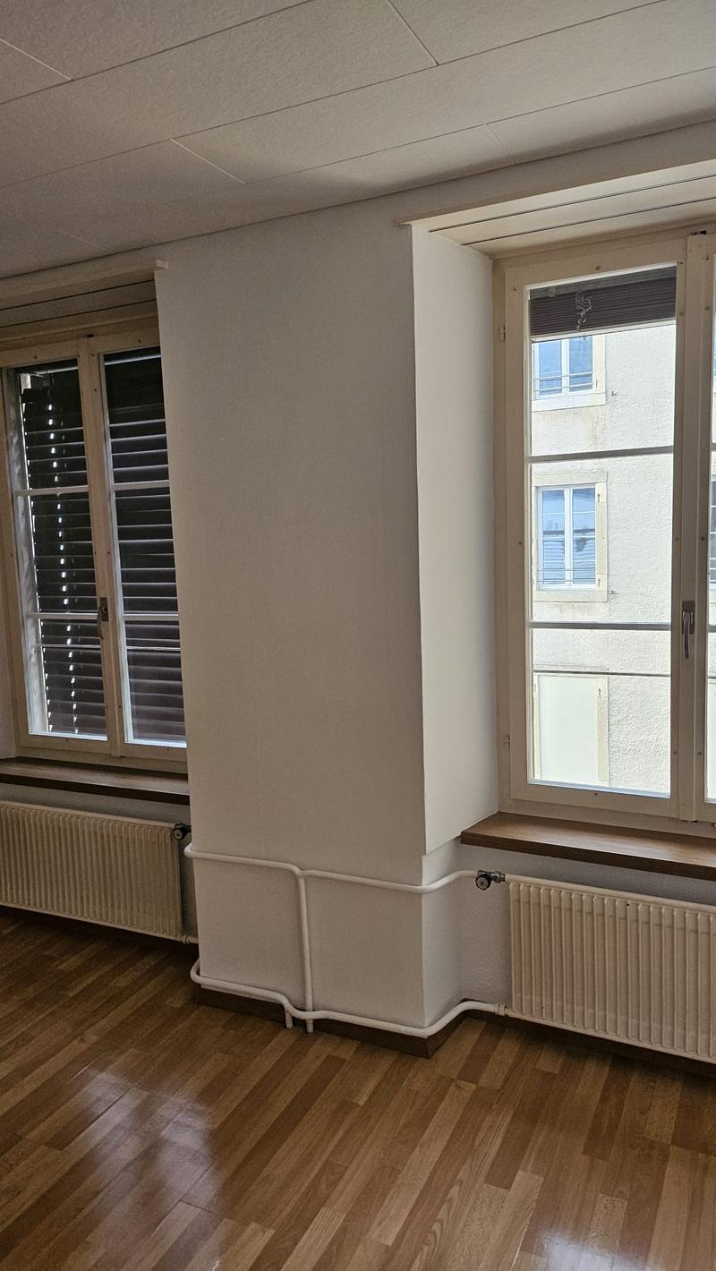 wide room, wooden floor, 2 windows, wall heater