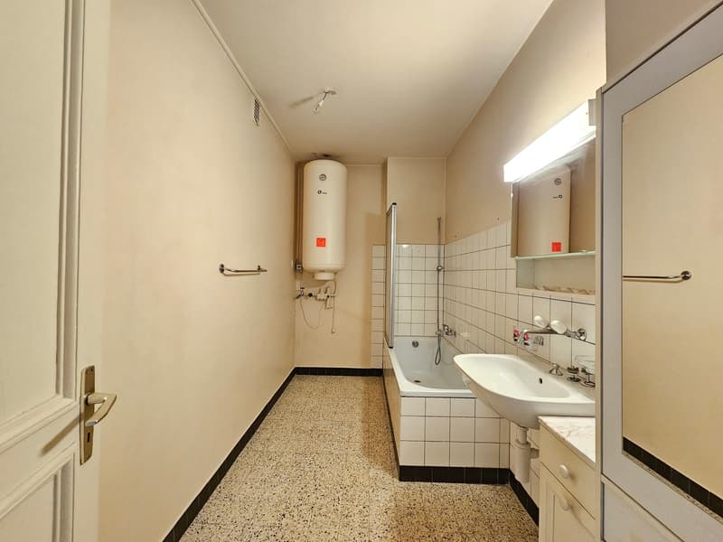 Bathroom with bathtub, sink, and mirror.