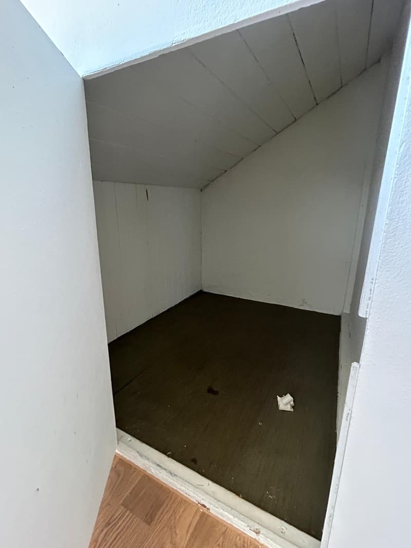 empty room, white walls, wooden floor, small dark floor