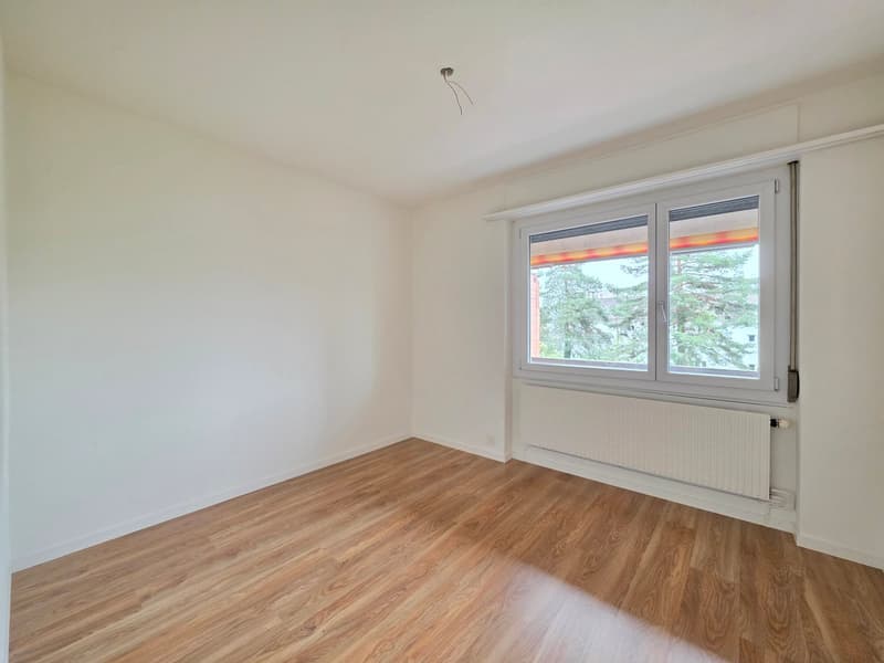 empty room, white walls, wooden floor, large window, white radiator