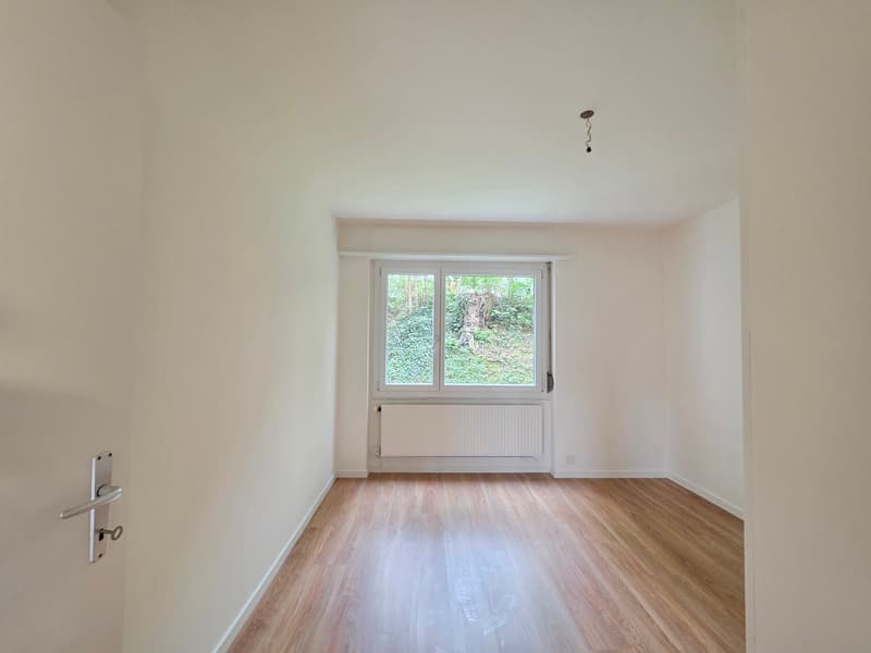 empty room, wooden floor, white walls, large window, white radiator