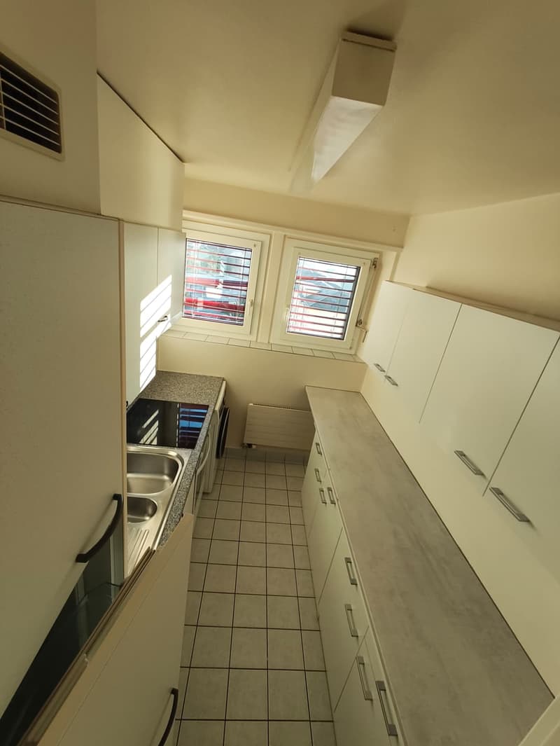 modern kitchen with white cabinets, tiled floor, double sink, gas stove, windows with blinds, white ceiling