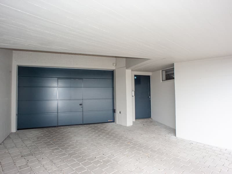 empty garage with a door, and another small door on the right side