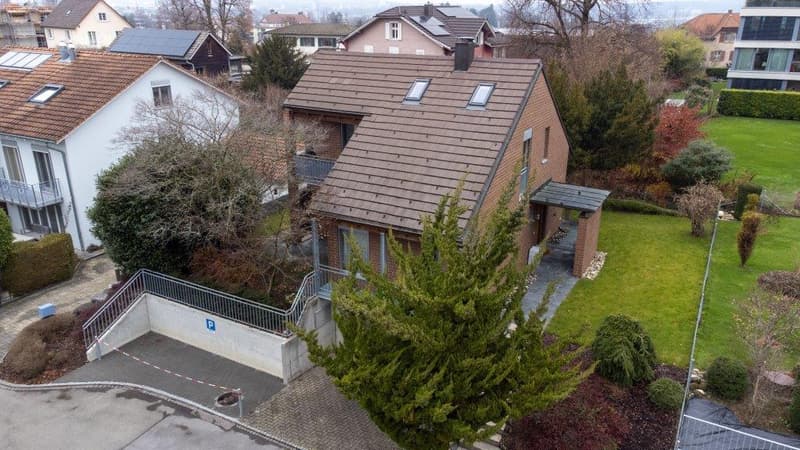 2 story house, brown roof, white walls, balcony, driveway, garden, trees