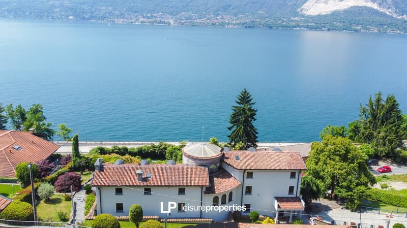 2 story house, white exterior, red roof, scenic waterfront location, trees, mountains