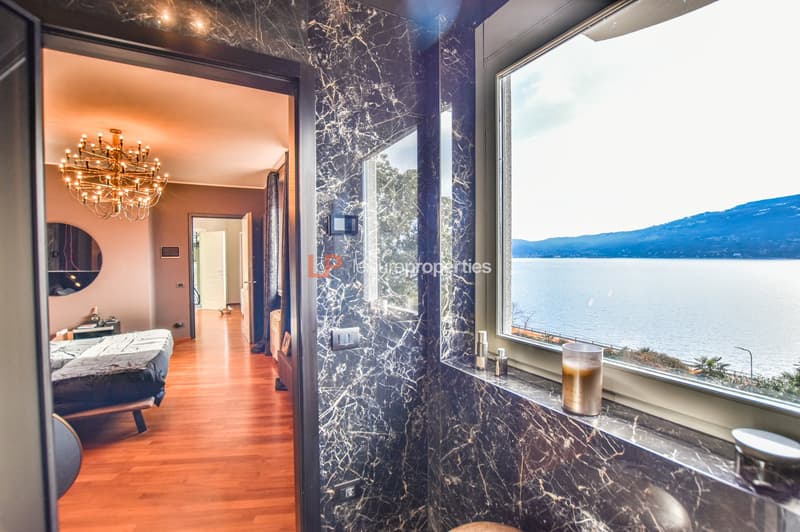 bed, chandelier, wooden floor, window with a lake view