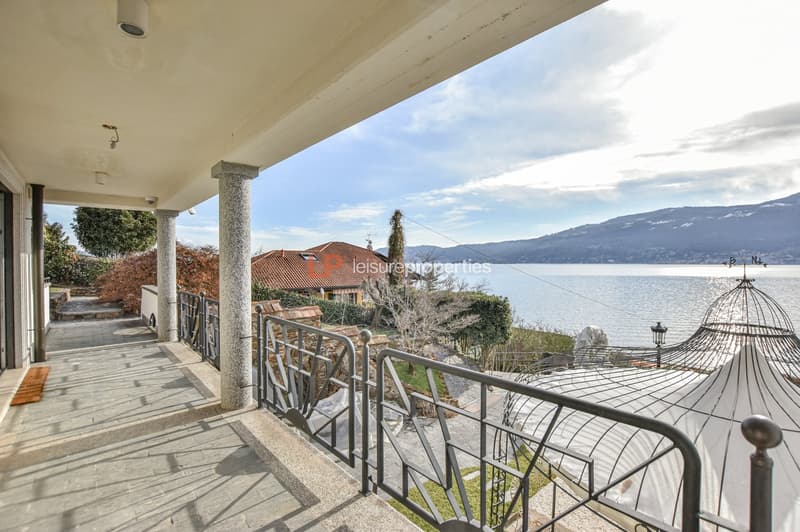 balcony with tiled floor, black railings, view of water and mountains