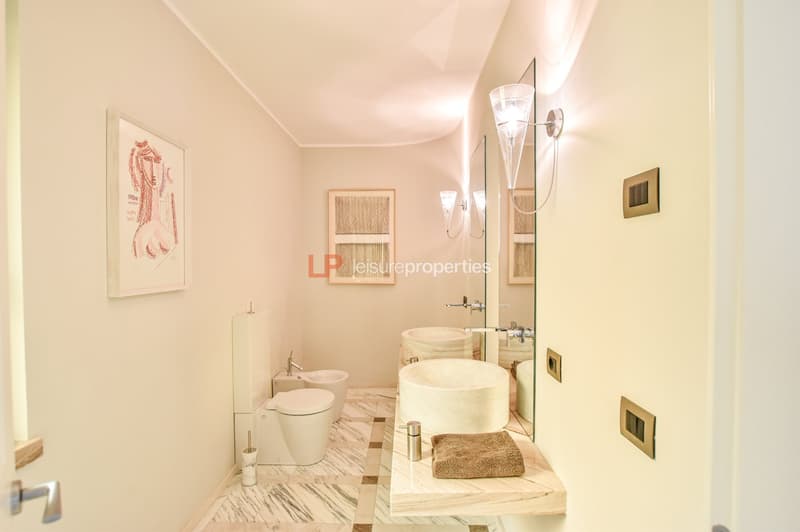 modern bathroom, two sinks, large mirror, picture frame, clean toilet, white flooring