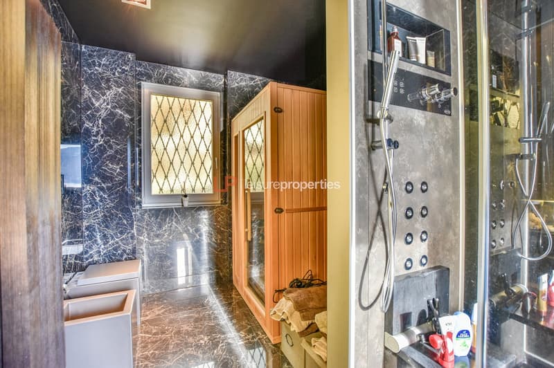 Marble walls, wooden cabinet, window, shower with control panel