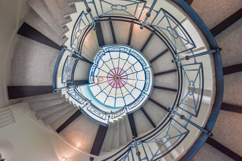 spiral staircase, decorative ceiling, blue railings, light coming through stained glass
