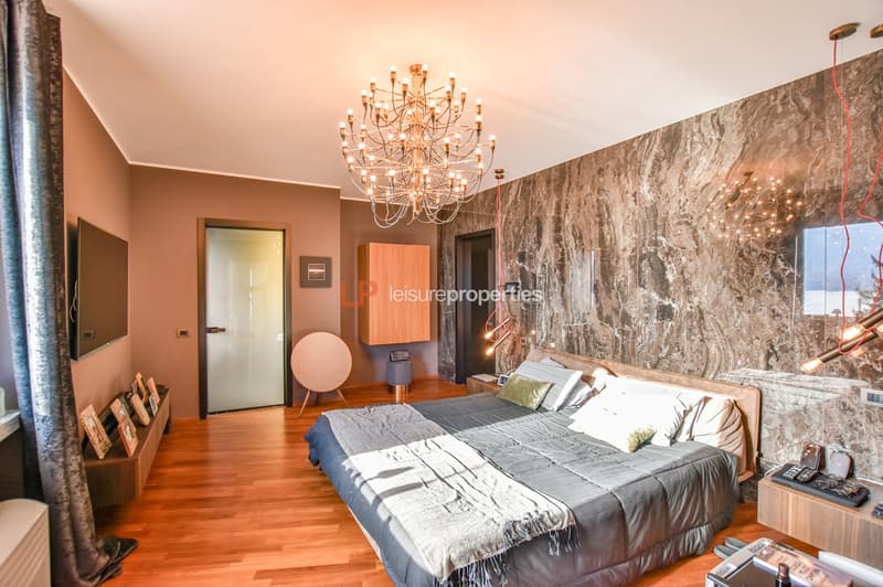 large bed, wooden floor, large chandelier, TV, nightstand, storage, wall decor, modern decor