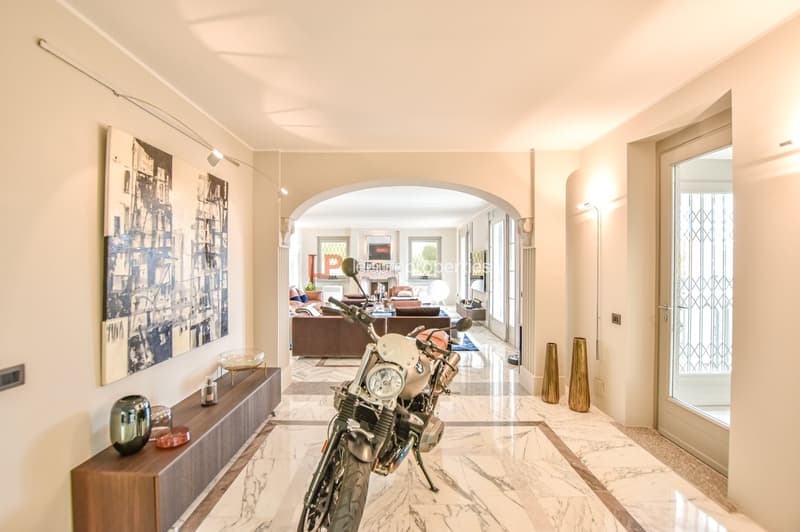 marble floor, arched entrance, hallway, motorcycle, decorative vases, artworks