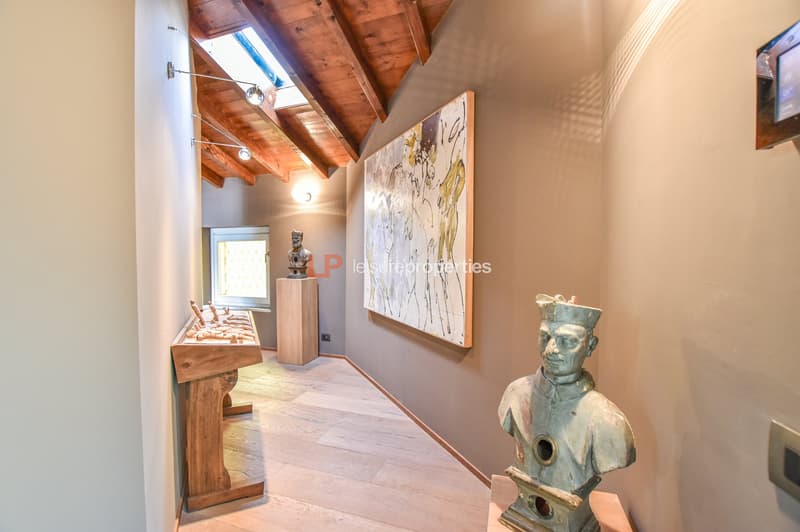 wooden ceiling, wooden floor, two busts, wall mounted lights, decorative painting