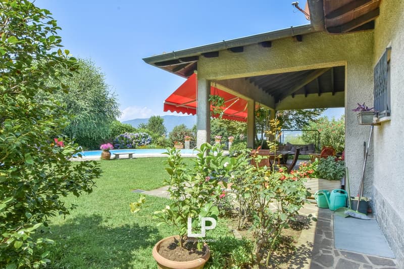 patio with awning, swimming pool, garden, trees, lawn, view of the mountains