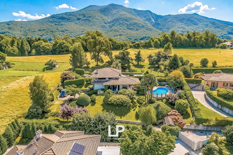 House with swimming pool, surrounded by green fields and mountains