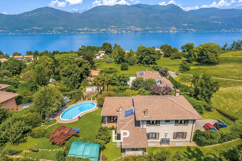 House with swimming pool, surrounded by greenery, with a view of the lake and mountains