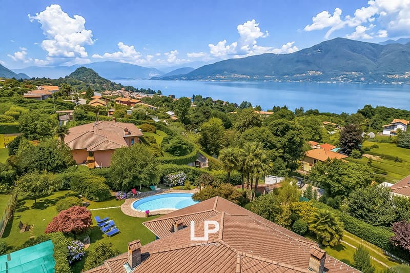 House with swimming pool, surrounded by trees and plants, with a view of the lake and mountains