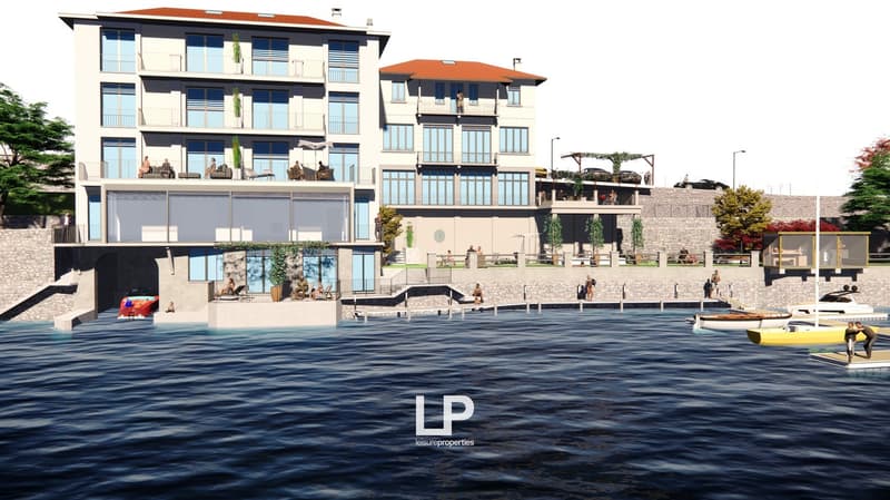 Large apartment building on waterfront with terraces, balconies, swimming pool, views of the water