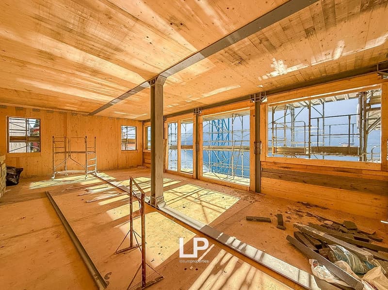 under construction, wooden ceiling and walls, large windows, scaffolding outside, wooden floor