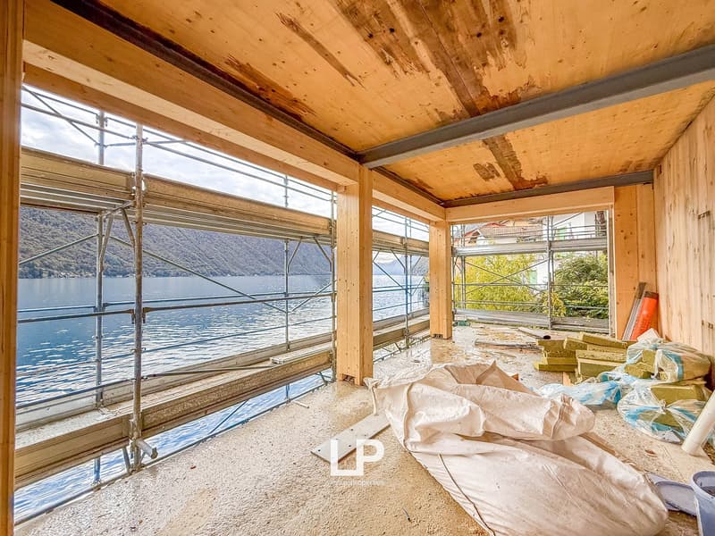 unfinished room, wooden ceiling, large windows overlooking the lake
