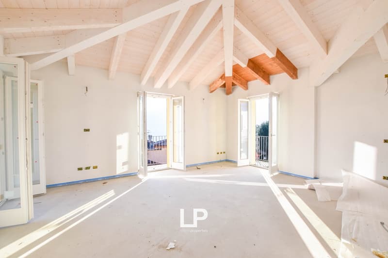 large open room, high ceilings, wooden beams, doors, balcony, light