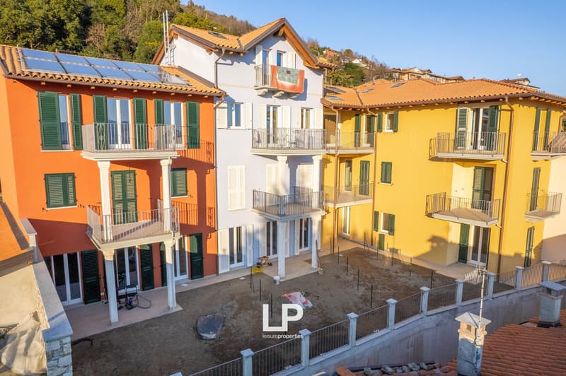 3 residential buildings, balconies, orange and yellow facade, solar panels
