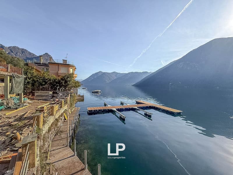 Building under construction, wooden dock, mountain range, lake