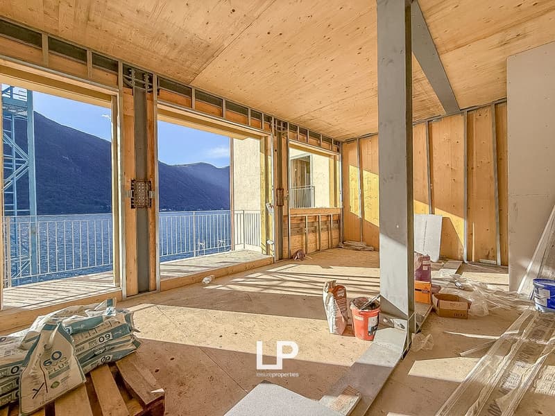 open room, balcony, large windows, wooden beams, construction materials