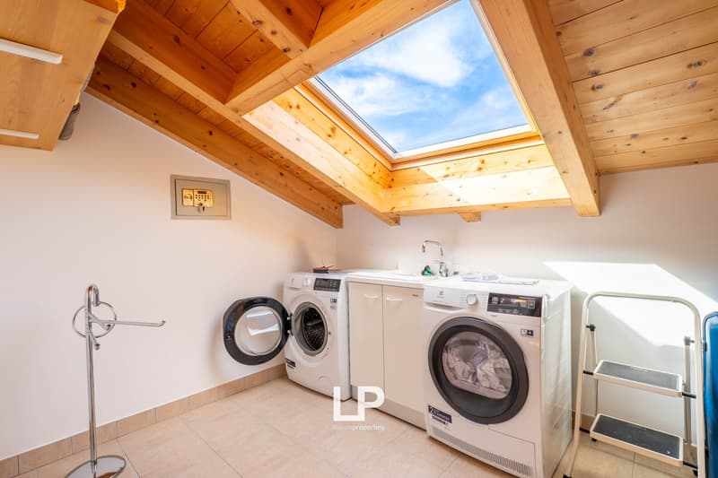 skylight, two washing machines, sink, hanging rack, tiled floor