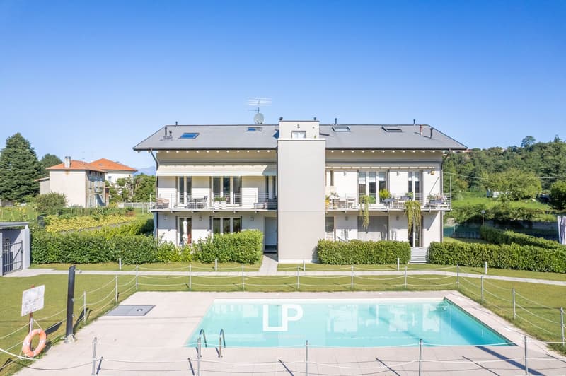 Large white house, modern style, two stories, large balcony, swimming pool in front, satellite dish
