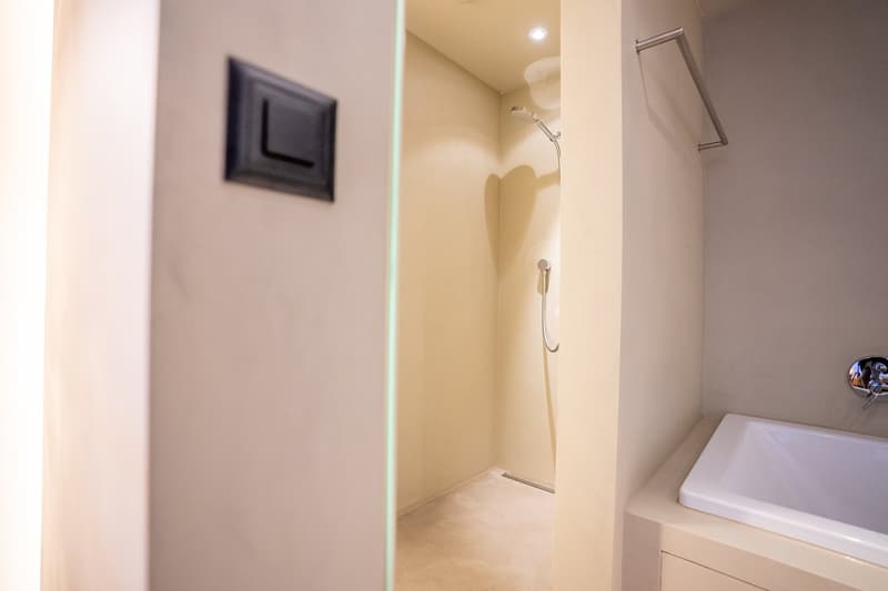 Bathroom with a shower stall, white walls, and a washing machine.