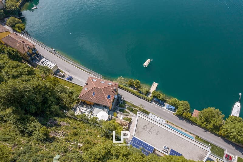 lakefront house with a pool, solar panels, car parking