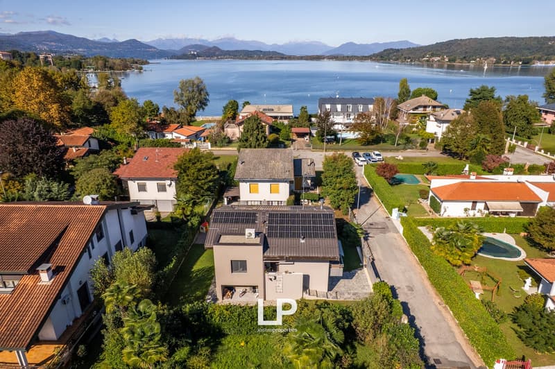 Modern house, solar panels, swimming pool, landscaped garden, scenic lake view
