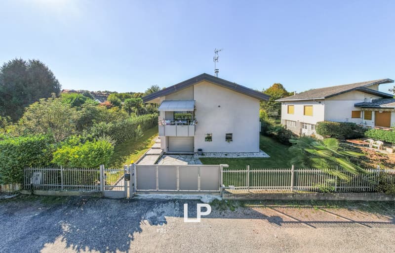 2 story house, white walls, gray roof, garage, large fenced yard