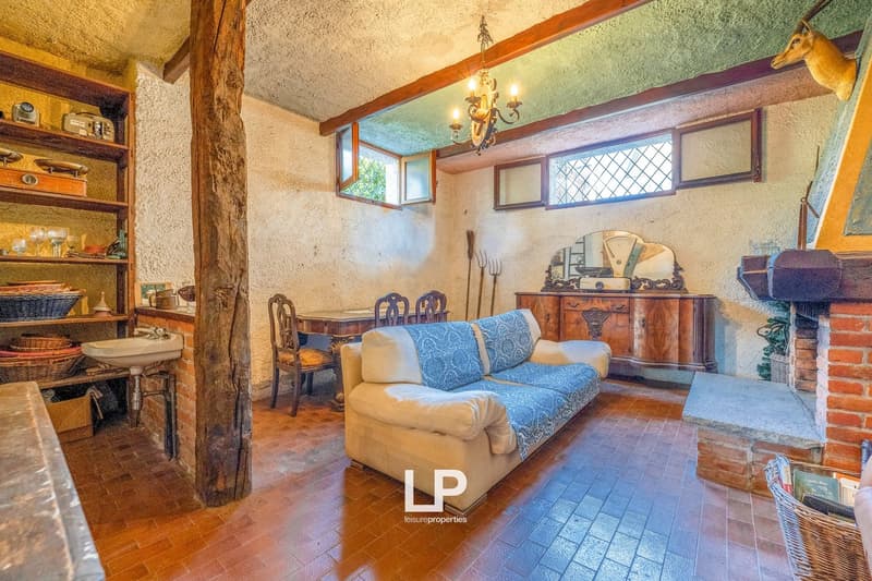 living room with fireplace, couch, dining table, cabinets, chandelier, shelves, tile flooring, decorative items
