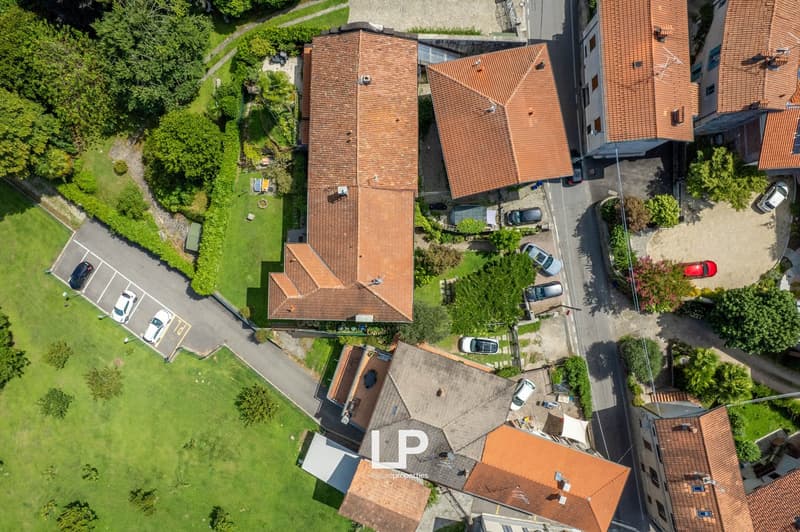 multiple residential buildings, brown roof tiles, parking spaces, trees and greenery in the area, clear road