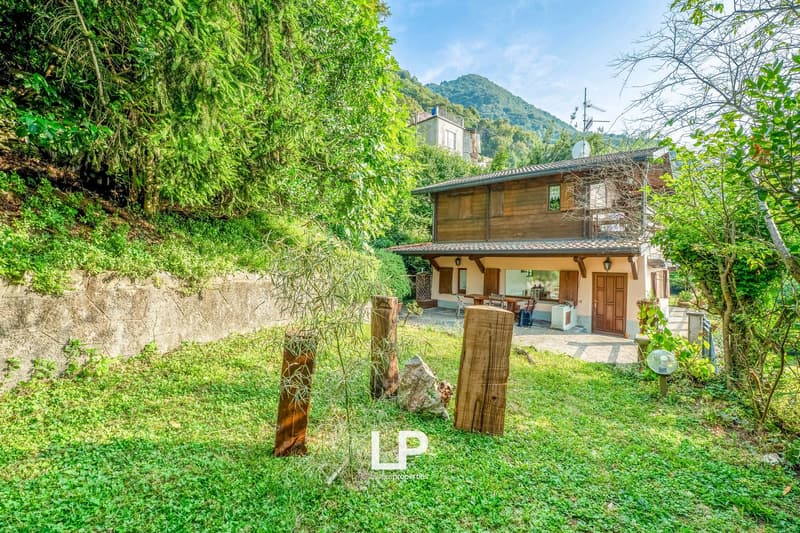 Wooden exterior, 2 story, exterior table and chairs, lawn, mountains in the background