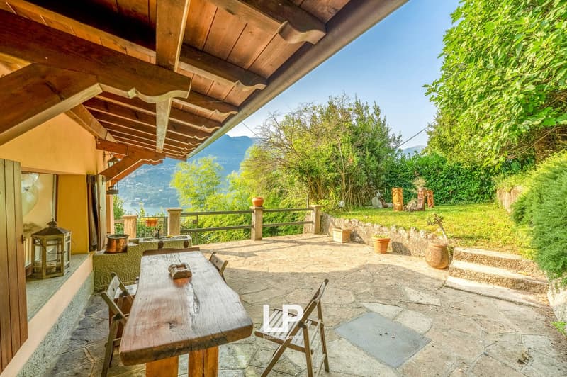 Outdoor dining table with chairs, wood ceiling, stone flooring, lantern, plants, steps, fenced area, mountain view