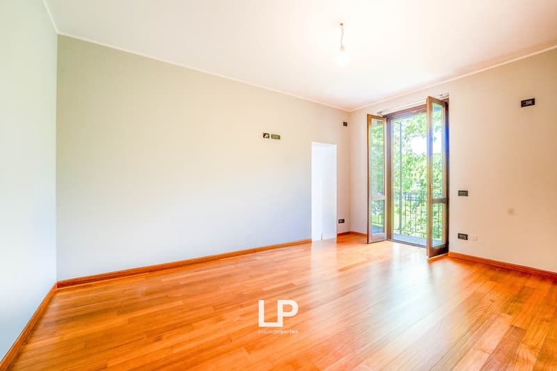 Open to balcony, hardwood floors, white walls, sliding glass doors