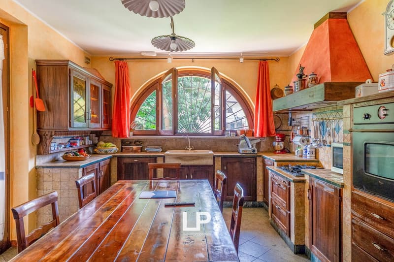large window, wooden table, kitchen counter, tiled flooring, wooden cabinets, open shelves, vintage stove