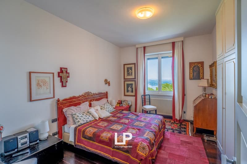 wood floor, king size bed, curtains, wall art, nightstand, window with view