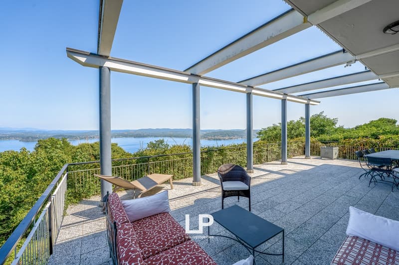 covered balcony, lounge chairs, table, chairs, water view