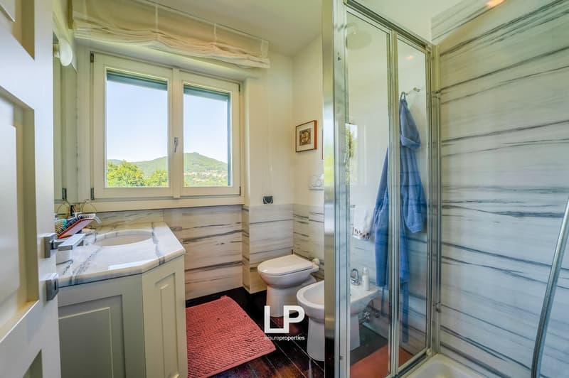 white and marble bathroom, sink, toilet, bidet, shower, picture frame