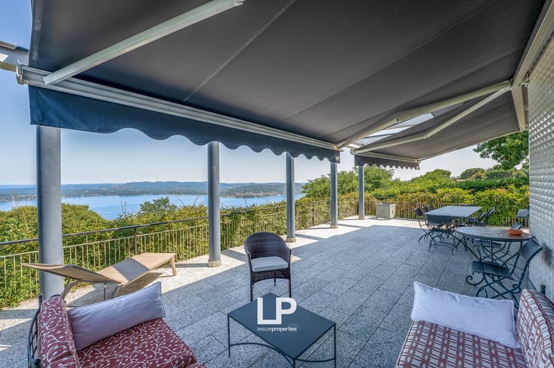 covered balcony with dining table, chairs, lounge chairs, couch, and coffee table