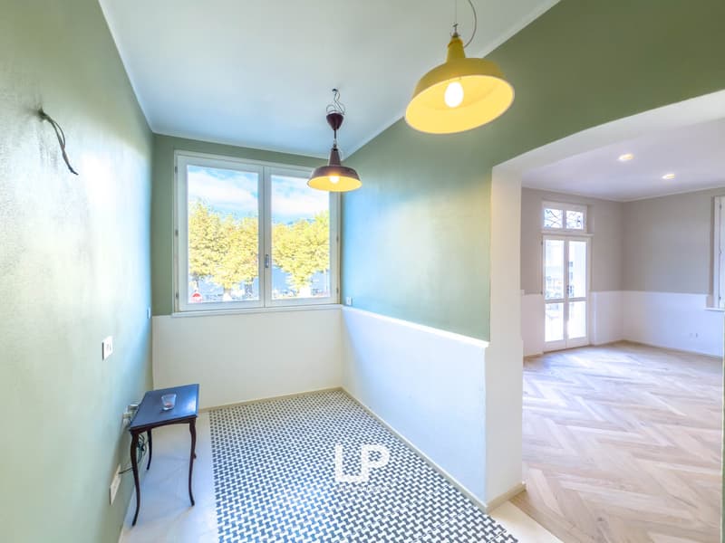 checkered floor, white walls, two windows, wooden floor in another room, open door